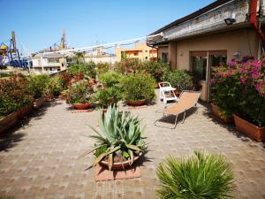 パレルモにあるLa Terrazza di Jennyの鉢植えの植物とテーブルと椅子が備わるパティオ