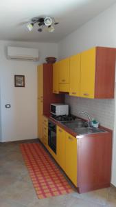 a kitchen with yellow cabinets and a sink at Le Villette di Consuelo in Pizzolungo