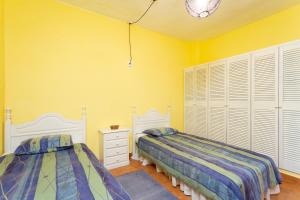 two beds in a room with yellow walls at Finca La Gaviota - El Granito in Icod de los Vinos +35 photos
