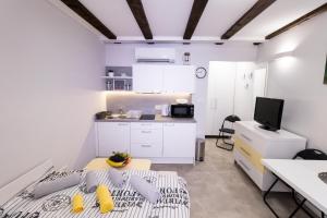 a small white kitchen with a table in a room at Apartments Bella Tara in Piran