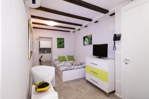 - une petite chambre avec un lit et une télévision dans l'établissement Apartments Bella Tara, à Piran