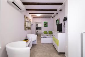 a small room with white furniture and a bed at Apartments Bella Tara in Piran
