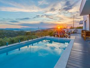 a swimming pool with a sunset in the background at Luxury Villa Ena in Grižane