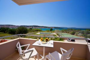 uma varanda com uma mesa e cadeiras e uma vista em Gliving365 Capital em Argostoli