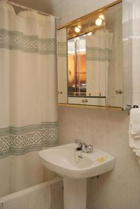 y baño con lavabo, espejo y bañera. en Hostal La Selecta, en Madrid