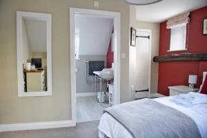 a bedroom with a bed and a sink and a mirror at The Three Horseshoes in Warham