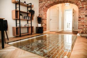 sala de estar con suelo de cristal y pared de ladrillo en Dönhoff Residence, en Pärnu