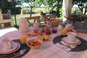 RicherenchesにあるLe Mas De La Seuveのピンクのテーブルクロスにかけた食べ物と飲み物を楽しめるテーブル