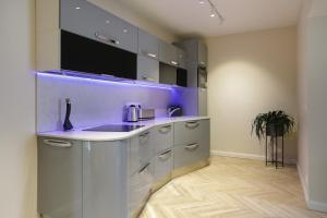 a kitchen with a sink and purple lighting at Dönhoff Residence in Pärnu