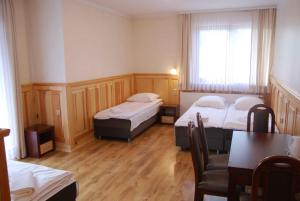 a room with two beds and a table and a dining room at Dom Wypoczynkowy Halina in Biały Dunajec