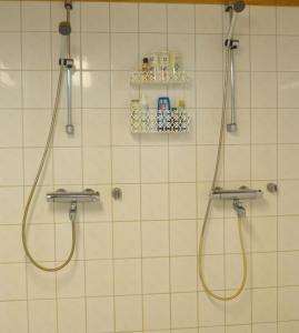 a bathroom with two shower heads and two faucets at Tenon Eräkievari in Karigasniemi