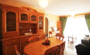 a living room with a wooden table and a kitchen at Jardin Del Mar in El Campello