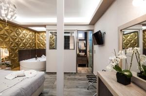 a bathroom with a bed and a tub and a sink at Garden Palace Hotel in Laganas