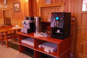 a kitchen with a coffee machine on a shelf with bottles at Dom Wypoczynkowy Halina in Biały Dunajec
