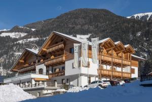 un edificio en la nieve con una montaña en Hotel Foestlerhof, en Villa Ottone