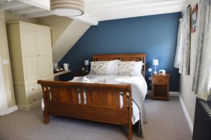 a bedroom with a bed and a blue wall at The Three Horseshoes in Warham