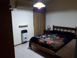 Un dormitorio con una cama con una manta. en Casa Temporaria en San Rafael