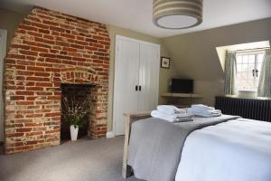a bedroom with a bed and a brick wall at The Three Horseshoes in Warham