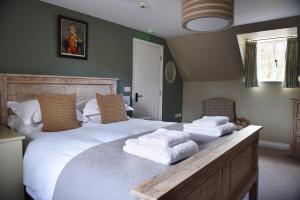 ein Schlafzimmer mit einem großen Bett mit Handtüchern darauf in der Unterkunft The Three Horseshoes in Warham