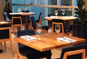 a table in a restaurant with wine glasses on it at Dazzler by Wyndham Rosario in Rosario