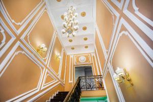 a staircase with a ceiling with a chandelier at Отель НЕАПОЛЬ in Moscow