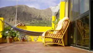 a hammock on a balcony with a view of a mountain at ponta gato residence in Tarrafal