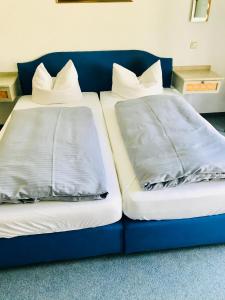 2 Betten nebeneinander auf einer blauen Couch in der Unterkunft Hotel Zum Forst in Kranzberg