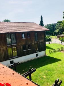 ein Gebäude mit einem Zaun und einem Rasenplatz in der Unterkunft Hotel Zum Forst in Kranzberg