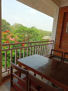 eine Veranda mit einem Tisch und Stühlen auf dem Balkon in der Unterkunft 行者之家SUNFLOWER in Rummindei