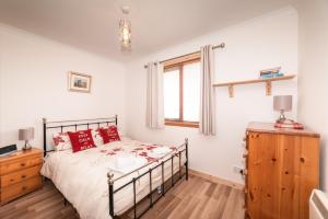 a bedroom with a bed and a window at The Wee Gem - 9 Milking Hill Park in Stornoway