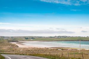 a road leading to a beach with the ocean at The Wee Gem - 9 Milking Hill Park in Stornoway
