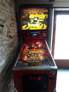 a pinball machine with a yellow car on the screen at Les Hôtes du Lac, Chambres et tables d'hôtes in Mandailles