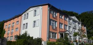 een wit gebouw met een bruin en wit bij Hotel Villa Subklew in Ostseebad Sellin