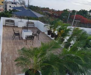 patio ze stołem, krzesłami i parasolem w obiekcie KSL Residence w mieście Boca Chica