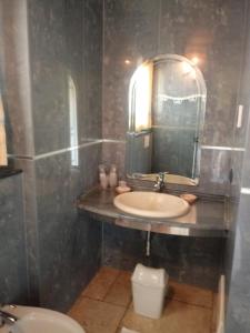 a bathroom with a sink and a mirror and a toilet at Hotel Corsaro Nero in Portu Maga