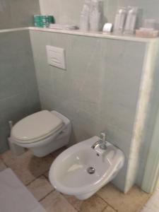 a bathroom with a white toilet and a sink at Hotel Corsaro Nero in Portu Maga