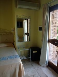 a bedroom with a bed and a mirror at Hotel Corsaro Nero in Portu Maga
