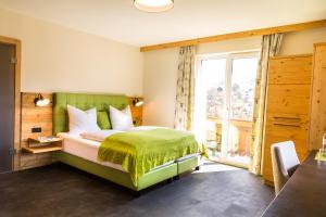 a bedroom with a green bed and a window at Hotel Hubertus in Sankt Johann im Pongau