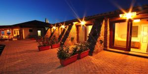 a brick building with potted plants and lights on it at Hotel Corsaro Nero in Portu Maga