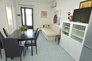 a living room with a dining room table and a couch at Casa Baia smeraldo in Leuca