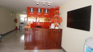 a lobby with a counter with a television and flowers on it at Khách sạn Hữu Phước in Quy Nhon
