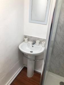 a white bathroom with a sink and a mirror at Wellington Tavern Bed and Breakfast in Dewsbury