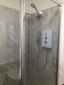 a shower with a shower head in a bathroom at Wellington Tavern Accommodation in Dewsbury