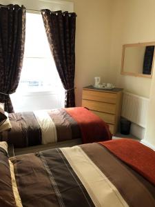 a bedroom with two beds and a window at Wellington Tavern Accommodation in Dewsbury +19 photos