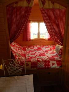 a bedroom with a red and white bed with a window at La Canfouine in Lamballe