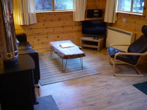uma sala de estar com uma mesa de centro e cadeiras em Dulnain em Aviemore