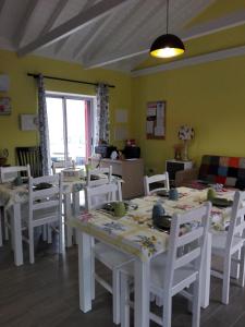 a dining room with white tables and white chairs at Ocean Breeze in Cais do Mourato