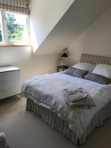 ein Schlafzimmer mit einem Bett mit einer Decke darauf in der Unterkunft Wimbledon Tennis House with Hot Tub; 4 minute walk in London