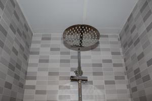ducha con ventilador en la pared de azulejos en Hostal Mirobriga, en Ciudad Rodrigo