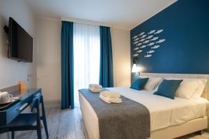 a bedroom with a large bed with a blue wall at Hotel Villa Eugenia - 3 Stelle Superior con Private SPA e Piscina in Lido di Jesolo